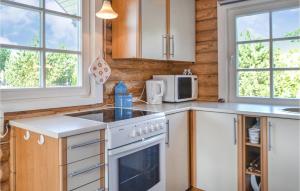 a kitchen with a stove and a microwave at Two-Bedroom Holiday Home In Hovborg in Hovborg