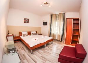 1 dormitorio con 1 cama grande y 1 silla roja en Rooms Eliza, en Zagreb