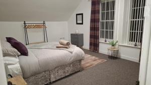 a bedroom with a bed and two windows at 3 Bed Flat - Sleeps 6 - Parking - Wifi in Antrim