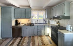 a kitchen with blue cabinets and a sink at 4 Bedroom Cozy Home In Svorkmo in Brattli