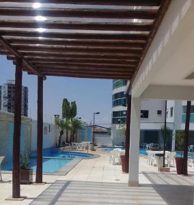 an outdoor patio with a pool and tables and chairs at Apartamento em Caldas Novas, GO, Cond Fiore Prime in Caldas Novas