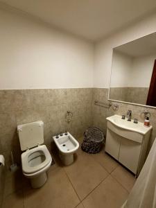 a bathroom with a toilet and a sink at Departamento en planta baja in Necochea +14 photos