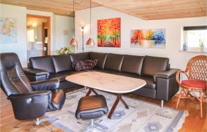 a living room with a couch and a table at Holiday Home Hindbærvangen Oksbøl V in Oksbøl