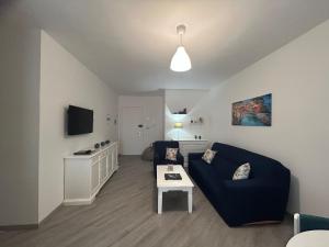 a living room with a blue couch and a table at SEA&SUN House in Marinella di Sarzana