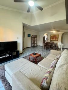 a living room with a couch and a flat screen tv at Acogedor departamento cerca de la playa in Mazatlán