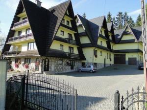 a large house with a car parked in front of it at Domek pod lasem in Białka Tatrzanska