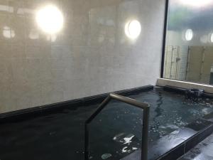 御殿場市にあるホテルクニミ御殿場の窓付きのバスルーム(水のプール付)
