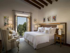 a bedroom with a large white bed and a chair at Holiday home with spacious lounge area in Banyalbufar