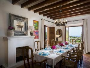 a dining room with a long table and a fireplace at Holiday home with spacious lounge area in Banyalbufar