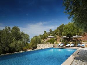 a swimming pool with chairs and umbrellas at Holiday home with spacious lounge area in Banyalbufar +32 photos