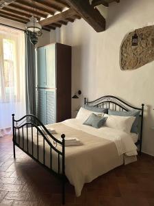 a bedroom with a large bed with white sheets at Il Girasole Storico in Pitigliano