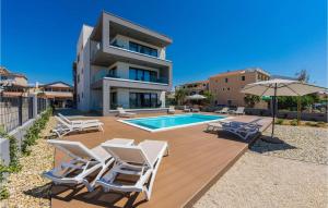 ヴィルにあるVilla Prezidaのスイミングプール、椅子、家が備わるヴィラです。