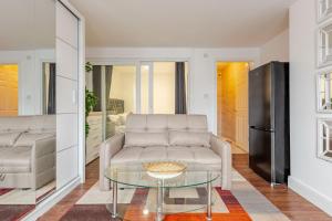 a living room with a couch and a glass table at Parkside Haven, Modern 2-Bed Flat with Ensuites, Free Parking & Self Check-In in Perivale