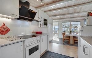 a kitchen with white appliances and a dining room at Three-Bedroom Holiday Home In Sydals in Østerby