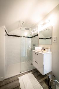 a white bathroom with a shower and a sink at Le Temps Retrouvé - 2 Chambres in Brive-la-Gaillarde