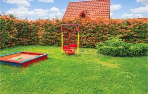 einen Spielplatz im Hof mit einer roten Schaukel in der Unterkunft Amazing Home In Kolczewo With Sauna in Kołczewo