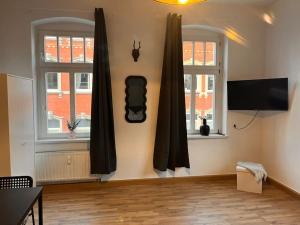 a living room with two windows and a flat screen tv at Das Blaue Wunder by Immo-Franzi in Rodewisch