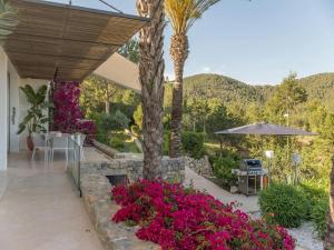 a patio with pink flowers and a palm tree at Villa in Ibiza near Salinas Beach in Sant Llorenç de Balafia