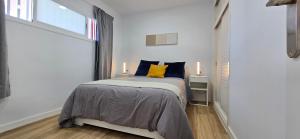 a bedroom with a bed with blue and yellow pillows at Refugio Del Mar in Playa del Ingles