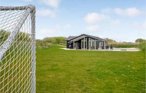 un edificio dietro una recinzione in un campo di Holiday Home Lakolk Rømø Denmark a Bolilmark