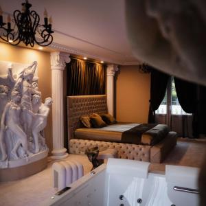a bedroom with a bed and a bath tub at Villa-Aphrodia love room in Thionville