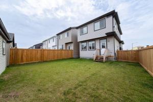 a backyard of a house with a wooden fence at The Nest, 3BR, AC, Near YEG Airport, King Bed! in Edmonton