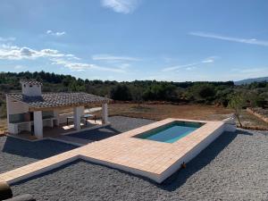 a swimming pool and a picnic table next to a house at La Llobatera Casa Rural in Les Coves de Vinroma