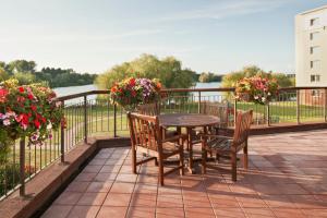 a table and chairs on a balcony with flowers at Holiday Inn Basildon, an IHG Hotel in Basildon