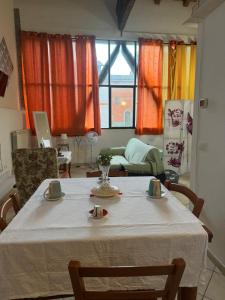 einen Tisch im Wohnzimmer mit einem weißen Tischtuch in der Unterkunft La corte dei celti la fonte 1 in San Benedetto Del Querceto
