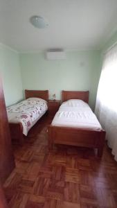 two beds in a room with wooden floors at Casa do Tonito in Carregal do Sal