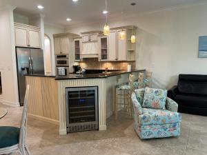 a kitchen with a fireplace and a couch and a chair at the Cape House in Cape Canaveral