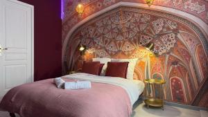 a bedroom with a large bed with a red wall at Namaste in Roubaix +17 photos