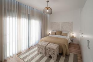 拉戈阿Lugar Da Ribeira的白色卧室设有大床和大窗户