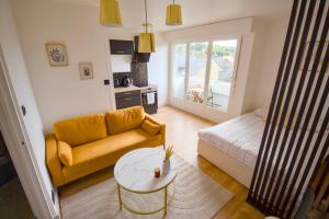 a living room with a couch and a table at La Duché - Appartement neuf central, calme, vue sur les toits de Cherbourg et Parking, intendance Luxury Host in Cherbourg en Cotentin