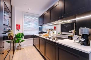 Una cocina con gabinetes negros y encimera. en King Street Collection, en Mánchester