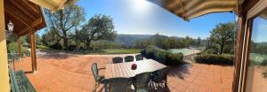 a table and chairs on a patio with a view at Villa vue panoramique, 6 chambres, piscine chauffée in Espalion