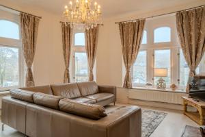 a living room with a couch and a chandelier at Palace View Apartment in Buxton