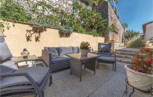 a patio with wicker chairs and tables and a wall at Two-Bedroom Apartment In Rabac in Rabac +23 photos