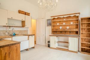 a kitchen with white cabinets and a chandelier at Palace View Apartment in Buxton