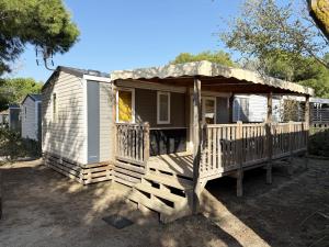 una piccola casa con portico e terrazza di Mobil-home - Camping Le Marisol - Torreilles-plage a Torreilles