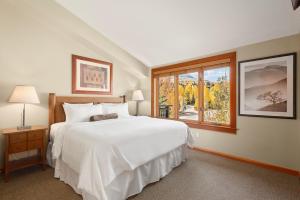 a bedroom with a large white bed and a window at Pinecone Perch Capitol Peak Lodge #3227 in Snowmass Village