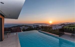 una piscina en la azotea de un edificio con puesta de sol en Villa Rhapsody 1 Aurelia 1, en Makarska
