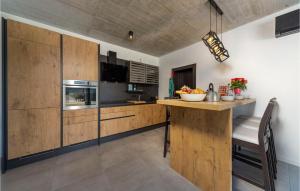 a kitchen with wooden cabinets and a counter with a table at Villa Bartolo in Labin