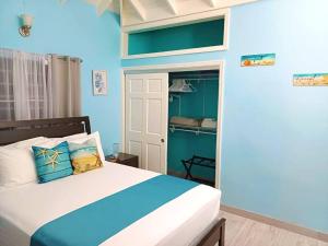 a blue bedroom with a bed and a closet at BlissVacay Couples or Singles Tropical Vacay Retreat in Creekside