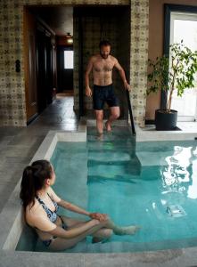 霍尔斯沃德吕尔Skálakot Manor Hotel的坐在游泳池里的男人和女人