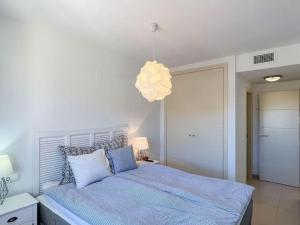 a bedroom with a bed and a light fixture at Las Flores 3 in Fuengirola +22 photos