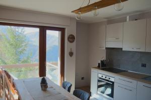 a kitchen with a table and a view of a mountain at Bilocale I cervi a pochi passi dalle piste con vista Mondolè in Prato Nevoso