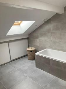 a bathroom with a bath tub and a ceiling at Joli duplex proche du lac Léman in Messery