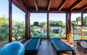 an indoor gym with two exercise machines and a large window at 4 Bedroom Lovely Home In San Giovanni in Montefiore dellʼAso +58 photos