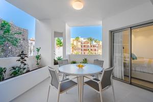 ein Esszimmer mit Tisch und Stühlen auf einem Balkon in der Unterkunft Luxury 2 bedrooms apartment in Palm-Mar, Tenerife in Palm-mar